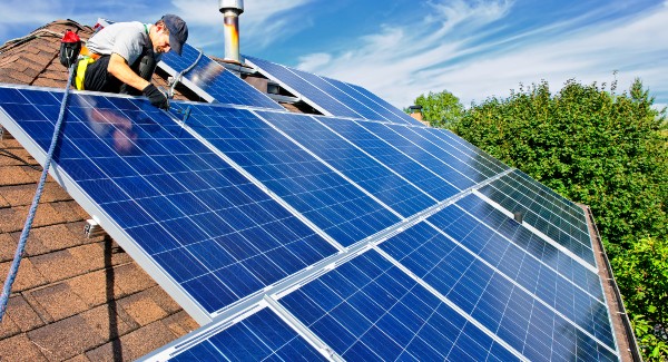 Man installing solar panels on roof